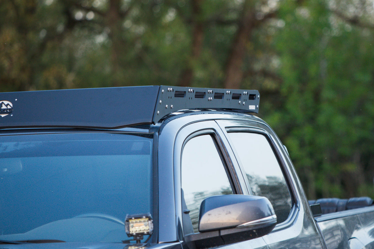 Détail du déflecteur avant et du panneau latéral de la plateforme de toit Freeland sur Toyota Tacoma 3e génération.